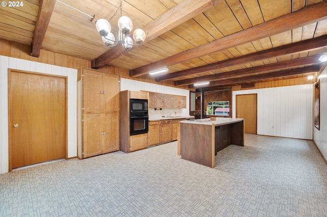 kitchen featuring wood walls, beamed ceiling, pendant lighting, wood ceiling, and black appliances