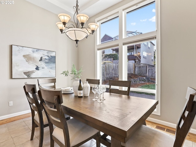 dining area with an inviting chandelier and light tile patterned floors