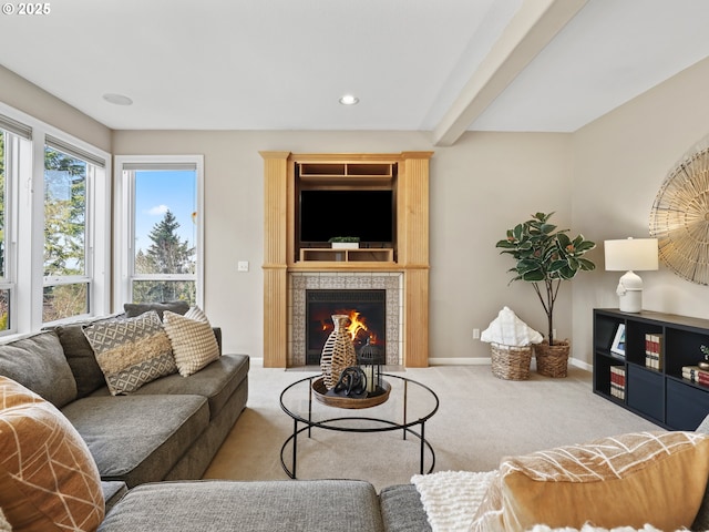 carpeted living room with beam ceiling and a tiled fireplace