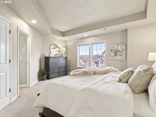 carpeted bedroom featuring a tray ceiling