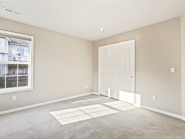 unfurnished bedroom with a closet and light carpet