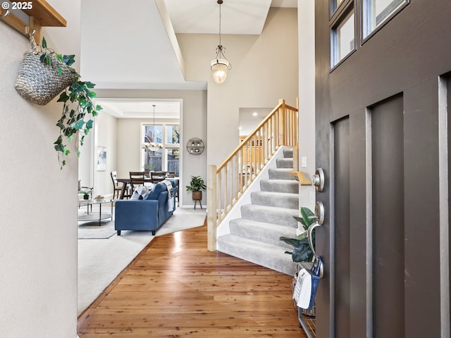 foyer entrance featuring hardwood / wood-style floors and a high ceiling