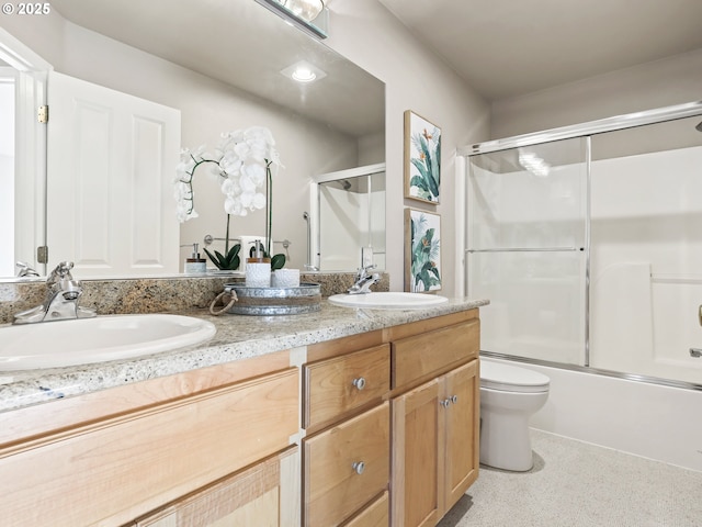 full bathroom with combined bath / shower with glass door, vanity, and toilet