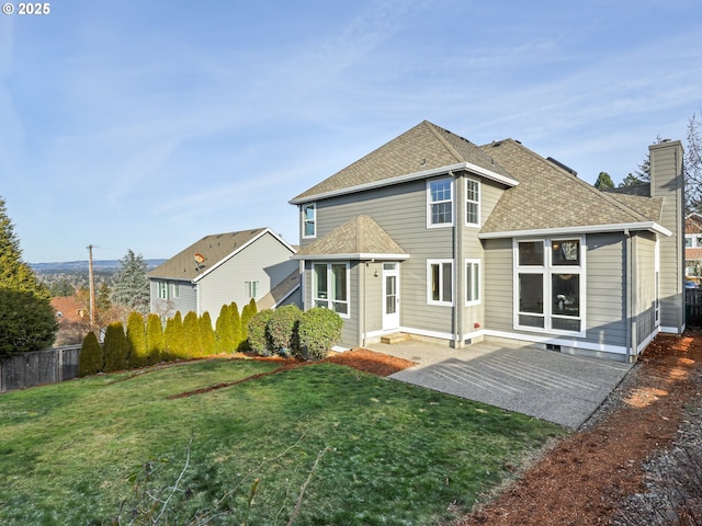 back of house featuring a lawn and a patio