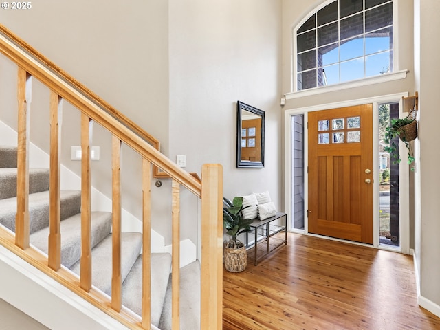 foyer with hardwood / wood-style flooring and a towering ceiling