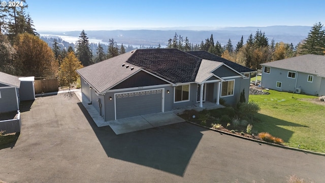 ranch-style house featuring a mountain view, a garage, and a front yard