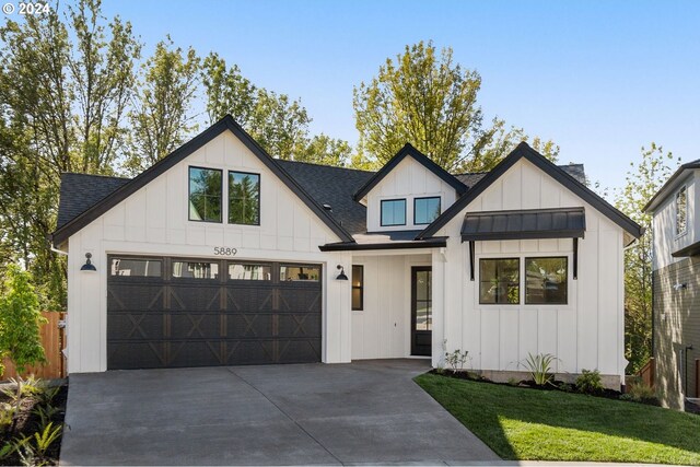 modern inspired farmhouse featuring a garage and a front yard