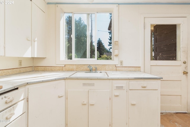 kitchen featuring light wood-type flooring, sink, and white cabinets