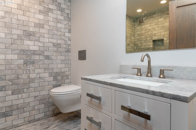 bathroom with walk in shower, vanity, toilet, and tile walls