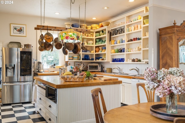 kitchen featuring light tile flooring, white cabinetry, wood counters, stainless steel fridge with ice dispenser, and white dishwasher