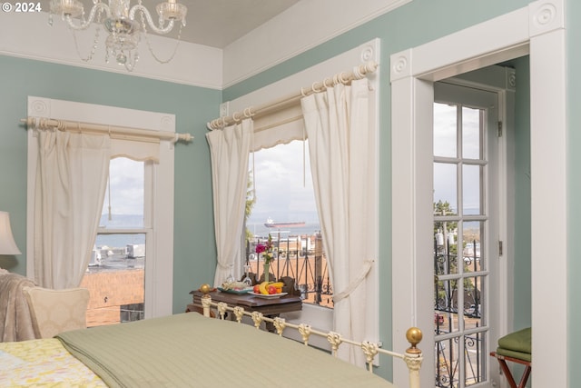 bedroom with a notable chandelier and a water view