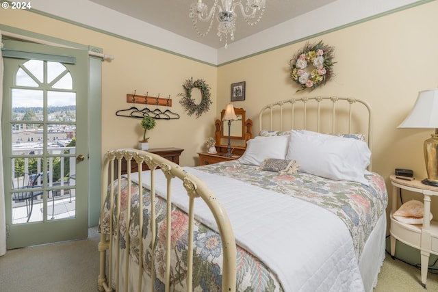 carpeted bedroom with an inviting chandelier and access to exterior