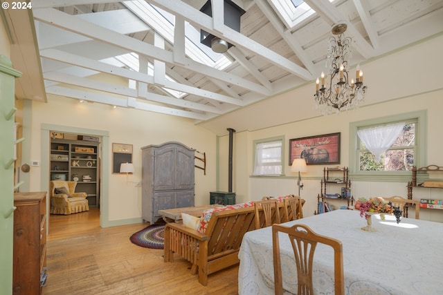 living room with a skylight, a notable chandelier, beamed ceiling, and hardwood / wood-style floors