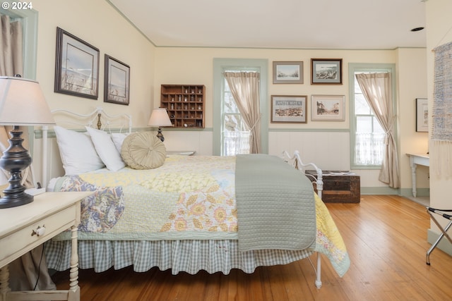 bedroom with hardwood / wood-style floors and multiple windows