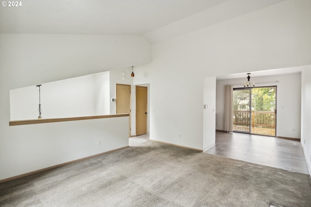 empty room with light carpet, high vaulted ceiling, and a chandelier