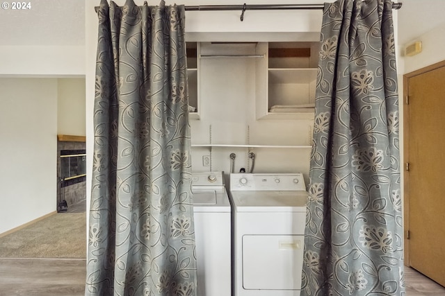 clothes washing area featuring washing machine and dryer and light hardwood / wood-style flooring