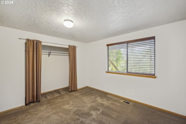 unfurnished bedroom featuring carpet floors, a textured ceiling, and a closet