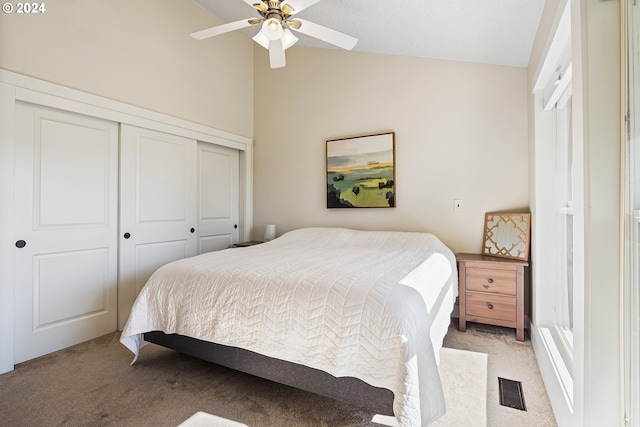 carpeted bedroom featuring a closet, ceiling fan, and lofted ceiling