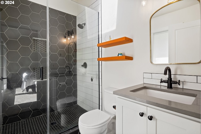 bathroom featuring vanity, toilet, and a shower with shower door