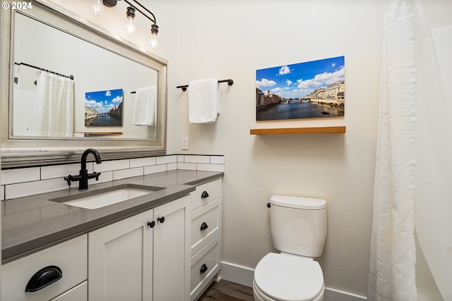 bathroom featuring decorative backsplash, vanity, hardwood / wood-style flooring, and toilet