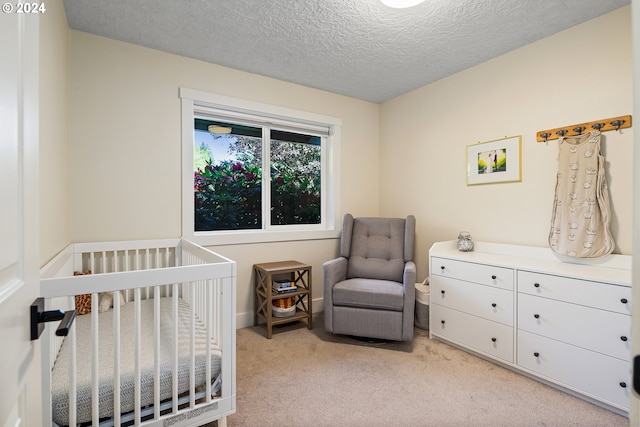 carpeted bedroom featuring a textured ceiling and a crib