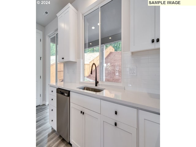 kitchen featuring dishwasher, backsplash, sink, light wood-type flooring, and white cabinetry