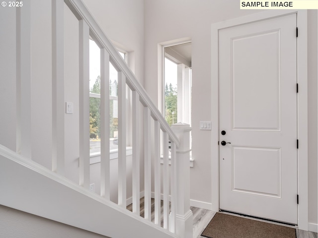 entrance foyer with stairs and baseboards