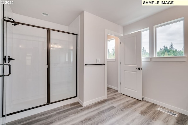 bathroom featuring hardwood / wood-style floors and a shower with shower door