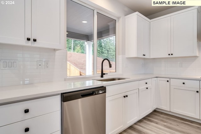 kitchen with dishwasher, light wood-type flooring, white cabinets, and sink