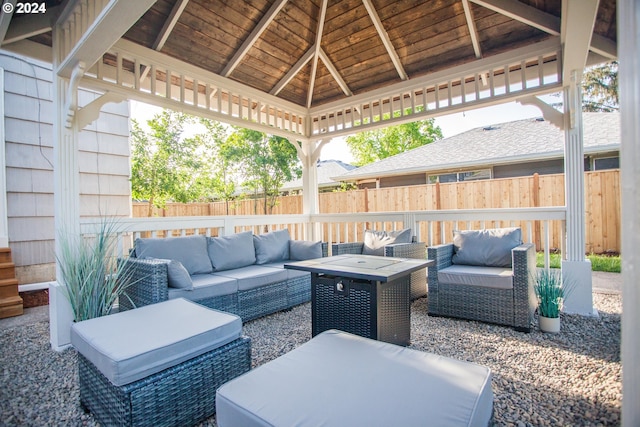 view of patio with an outdoor living space with a fire pit, fence, and a gazebo