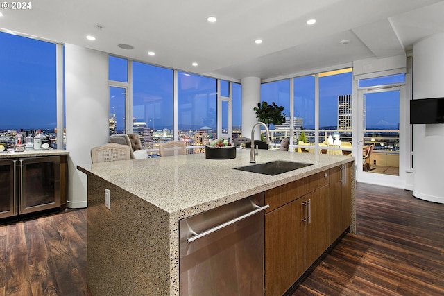 kitchen with dishwasher, a center island with sink, dark wood-type flooring, and sink