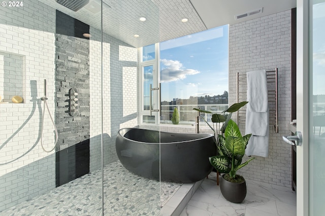 bathroom with a bath, expansive windows, and plenty of natural light