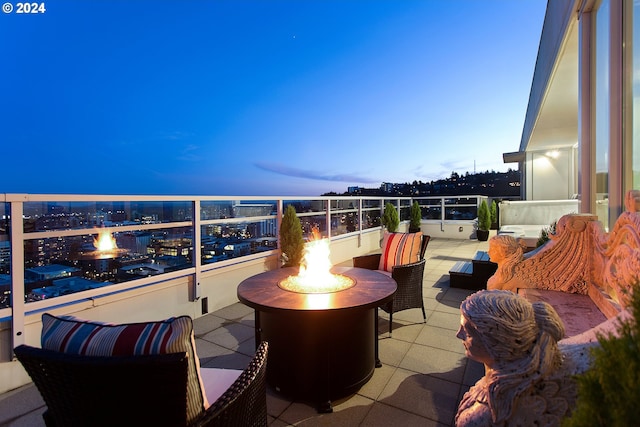 balcony at dusk with an outdoor living space with a fire pit