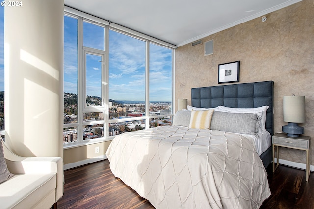 bedroom featuring dark hardwood / wood-style floors, crown molding, and multiple windows