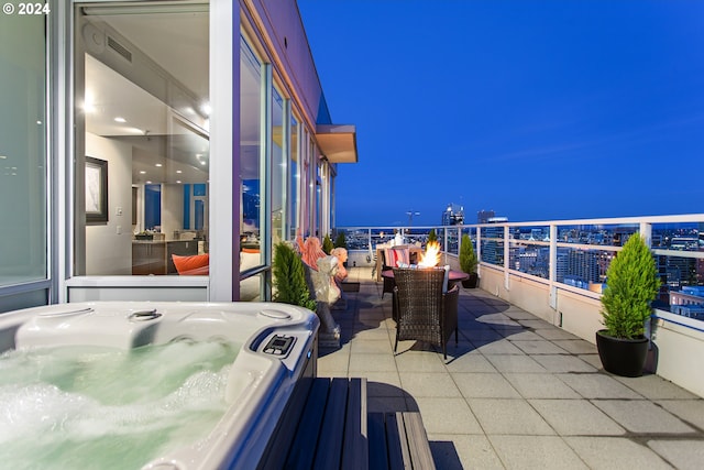 view of patio / terrace with a fire pit and a hot tub