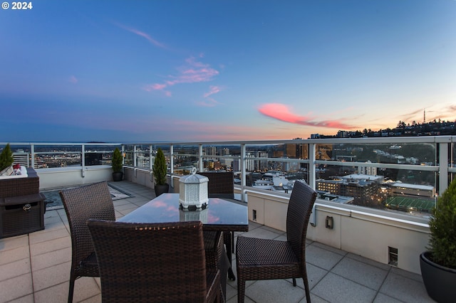 patio terrace at dusk featuring a balcony