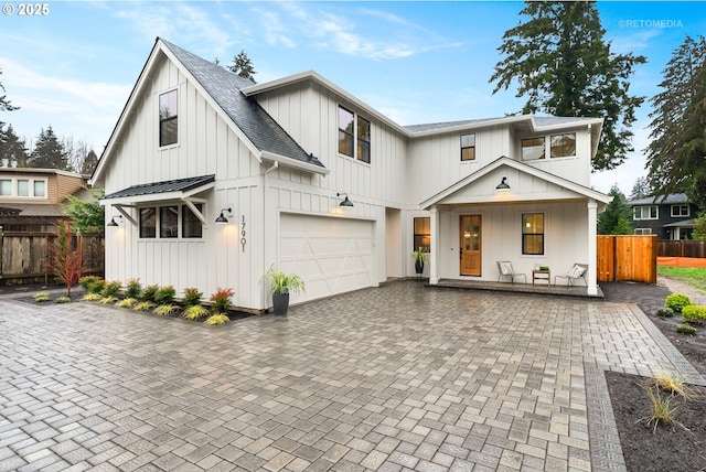 modern inspired farmhouse featuring a porch and a garage