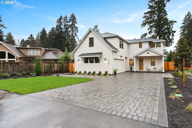 modern inspired farmhouse featuring a garage and a front yard