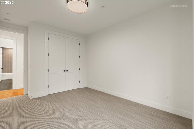 unfurnished bedroom with light carpet and a closet