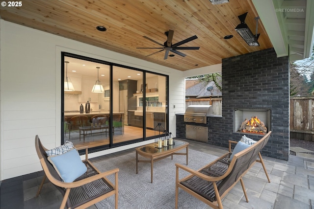 view of patio with an outdoor brick fireplace, a grill, and ceiling fan