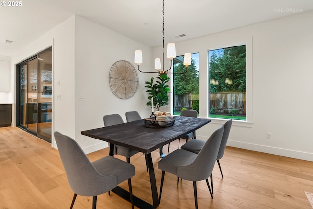 dining room featuring light wood-type flooring and a chandelier