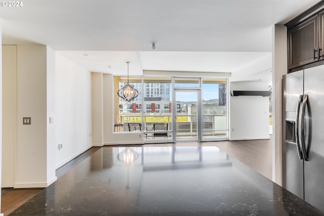 unfurnished dining area with baseboards and a chandelier