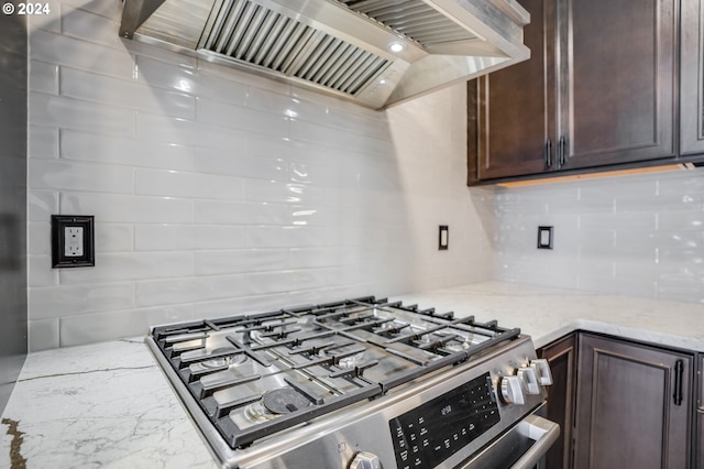 kitchen featuring tasteful backsplash, dark brown cabinets, ventilation hood, and stainless steel range with gas cooktop