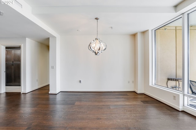 unfurnished dining area with a notable chandelier, wood finished floors, and baseboards