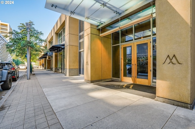 property entrance featuring stucco siding and french doors