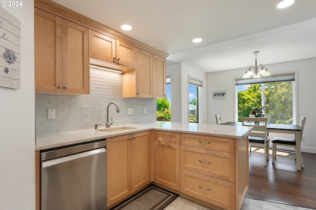 kitchen with decorative backsplash, stainless steel dishwasher, light stone countertops, a sink, and a peninsula