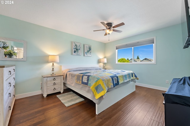 bedroom featuring baseboards, a ceiling fan, and dark wood-style flooring