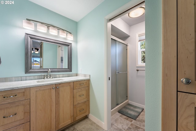 bathroom featuring vanity, baseboards, and a stall shower