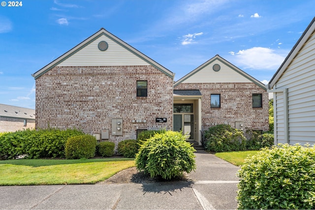 view of front of property featuring brick siding and a front yard