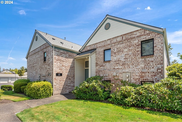 view of front of house featuring brick siding and a front yard